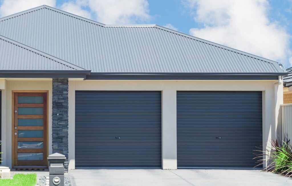 Roller doors Gliderol A modern home featuring two matching blue Gliderol roller garage doors side-by-side - Gliderol